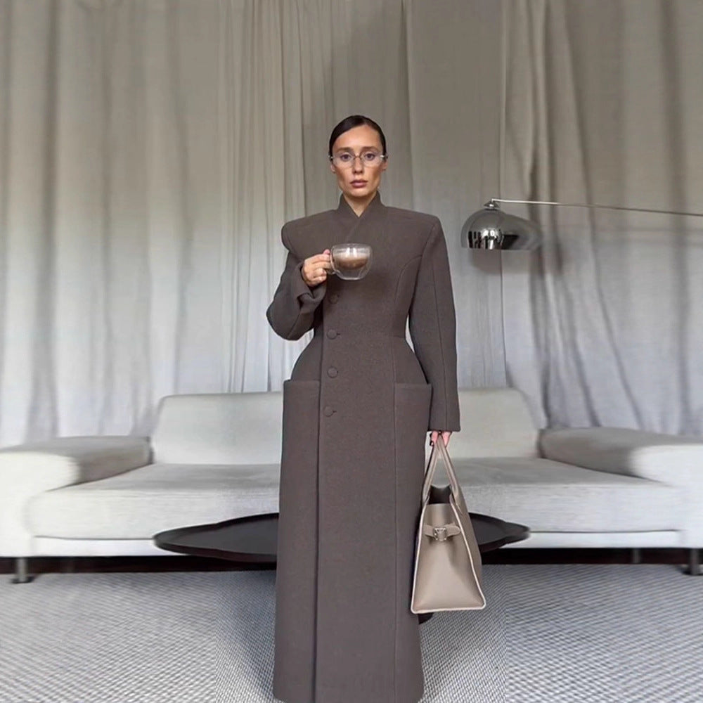 Manteau long en laine pour femme, épaules structurées et taille cintrée.