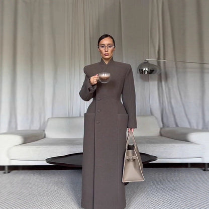 Manteau long en laine pour femme, épaules structurées et taille cintrée.
